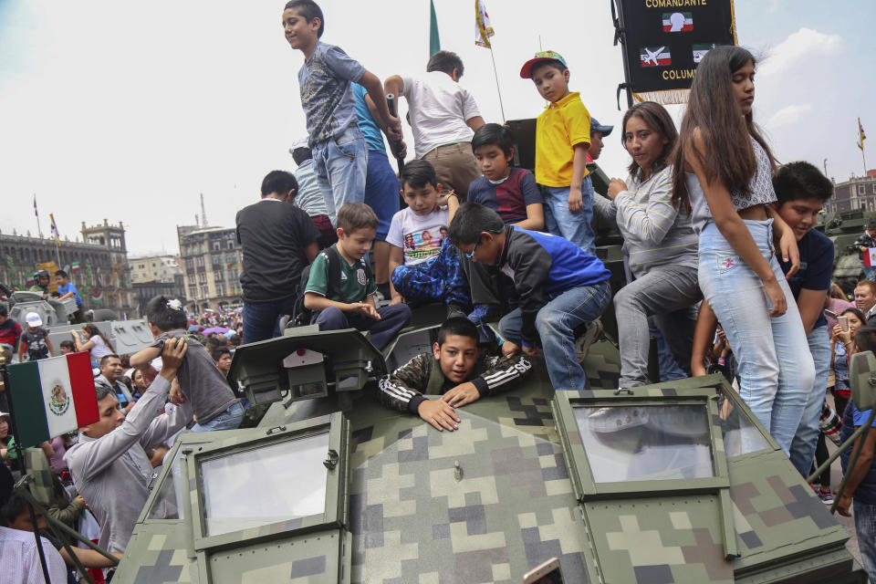 Children climb on a military vehicle displayed for Independence Day after a military parade, in the Zocalo of Mexico City, Sunday, Sept. 16, 2018. Mexico is celebrated its independence from Spain. (AP Photo/Anthony Vazquez)