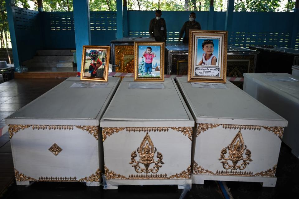 Portraits of victims sit atop coffins at Wat Si Uthai temple (Getty Images)