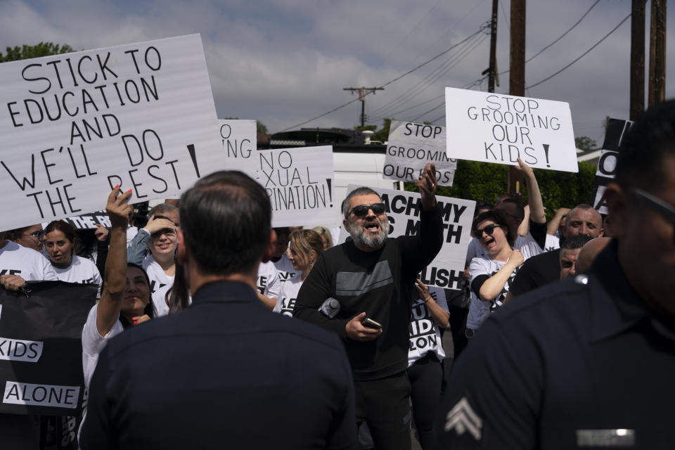 People protesting a planned Pride month assembly exchange words with counterprotestors outside Saticoy Elementary School in Los Angeles, Friday, June 2, 2023. Police officers separated groups of protesters and counter protesters Friday outside the elementary school that has become a flashpoint for Pride month events across California. (AP Photo/Jae C. Hong)