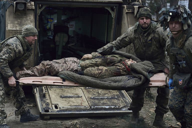 Médicos militares intentan dar primeros auxilios a un soldado gravemente herido en una batalla con los invasores rusos, que murió más tarde a manos de ellos, cerca de Kremenna en la región de Lugansk, Ucrania, el viernes 13 de enero de 2023. (AP/LIBKOS)