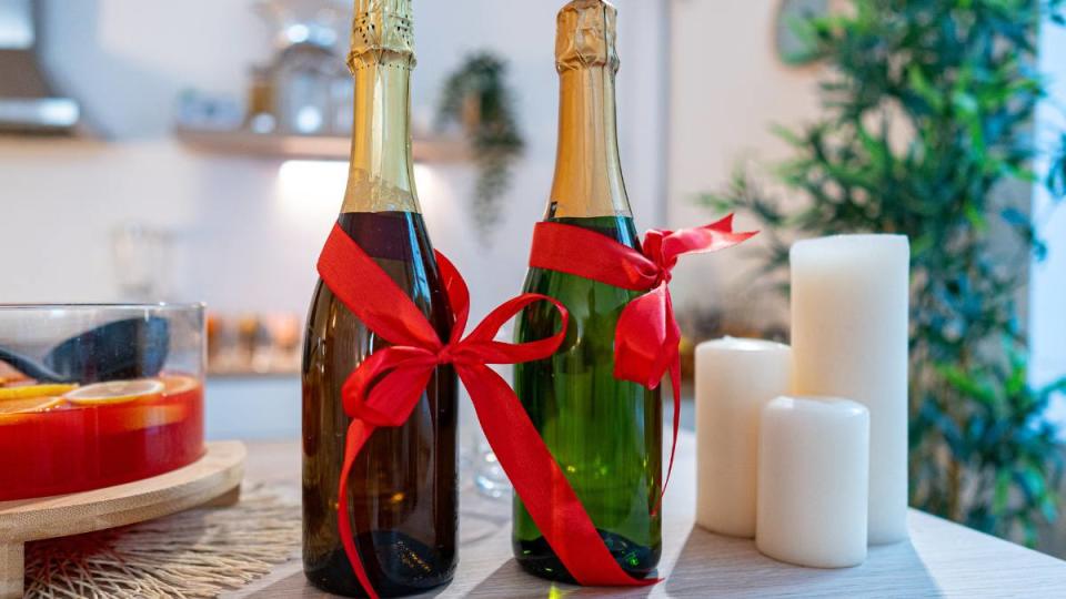 Candles, punch and champagne bottles with a bow on the table