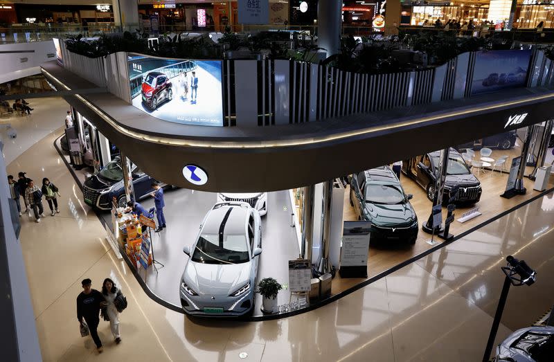 Electric vehicle (EV) models are displayed at the booths of Denza and Chinese EV maker Voyah, at a shopping mall in Beijing