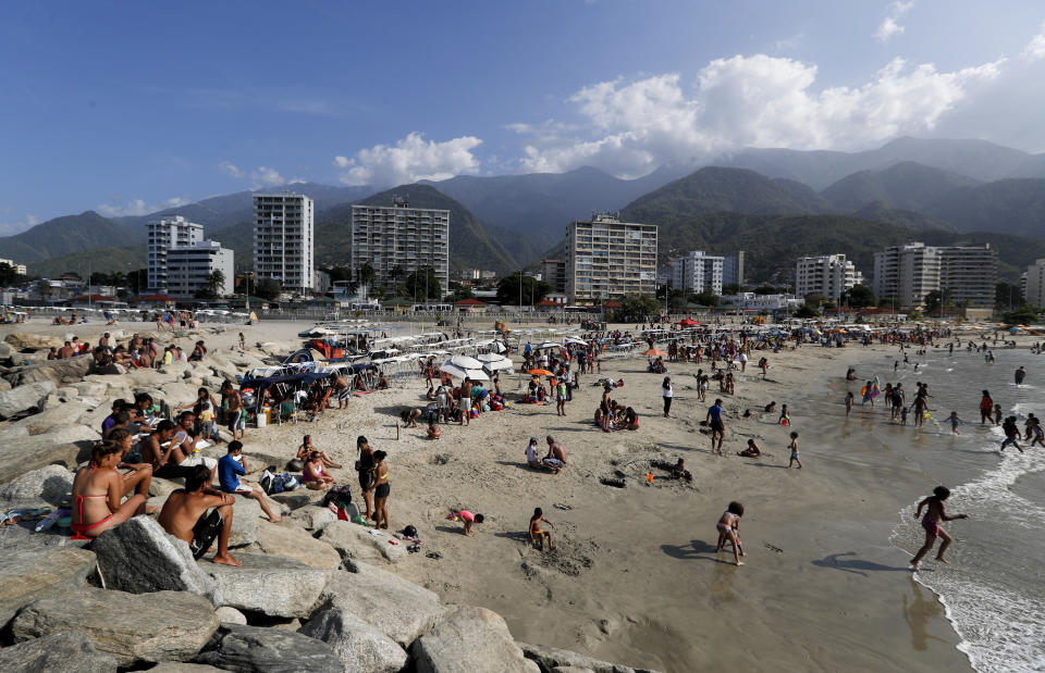 People enjoy Camuri Chico beach in Vargas state, Venezuela, Friday, March 1, 2019. It’s carnival season in Venezuela, though many citizens are not in a mood to party, as the country is gripped by a political crisis that pits leader Nicolas Maduro against Juan Guaido, the opposition chief who was in Paraguay on Friday as part of a campaign to build international pressure on his rival to quit. (AP Photo/Eduardo Verdugo)