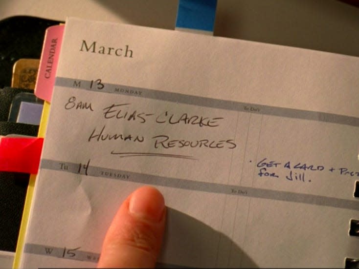 finger pointing to a date in a planner in devil wears prada