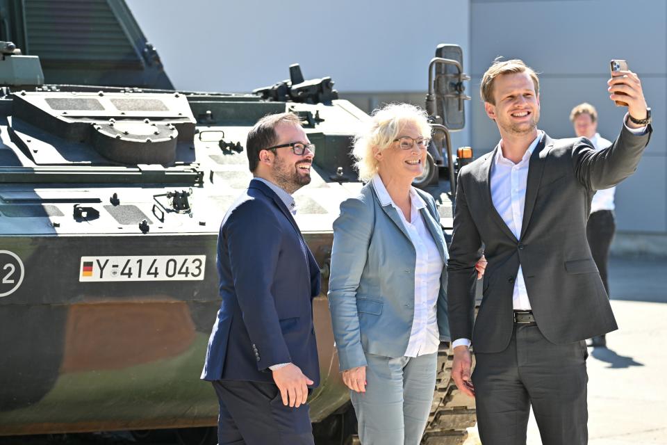 Christine Lambrecht, Bundesministerin der Verteidigung, macht vor einer Panzerhaubitze 2000 mit Robin Mesarosch (rechts), SPD-Abgeordneter, und Jan Rothenbacher, Kreisvorsitzender der SPD Alb-Donau-Kreis (l), ein Selfie in der Alb-Kaserne. - Copyright: picture alliance/dpa | Felix Kästle