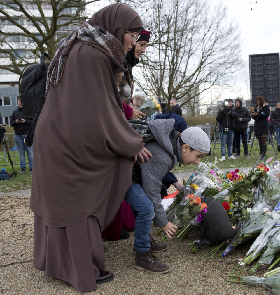 Mourners pay heir respect at a makeshift memorial at the site of a shooting incident in a tram in Utrecht, Netherlands, Tuesday, March 19, 2019. A gunman killed three people and wounded others on a tram in the central Dutch city of Utrecht Monday March 18, 2019. (AP Photo/Peter Dejong)