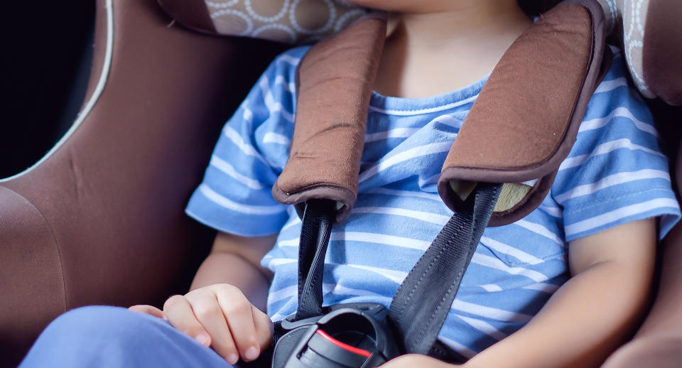 A toddle pictured in a car seat.