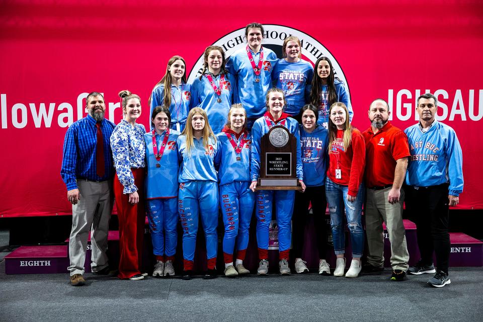 East Buchanan wrestlers pose for a photo with their second place trophy in the finals during the IGHSAU state girls wrestling tournament, Friday, Feb. 3, 2023, at the Xtream Arena in Coralville, Iowa.