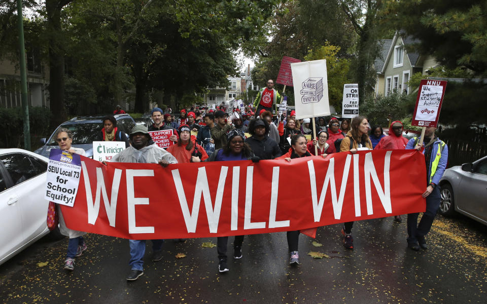 Dozens of Chicago Teachers Union members and supporters march through the streets of Chicago's Hyde Park neighborhood during the "Nurse in Every School" Solidarity March for Justice on Monday, Oct. 21, 2019. (Antonio Perez/Chicago Tribune via AP)