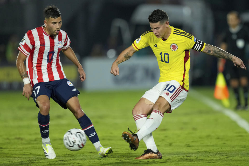 Colombia's James Rodriguez connects a shot under the watch of Paraguay's Ivan Leguizamon during a qualifying soccer match for the FIFA World Cup 2026 at the Defensores del Chaco stadium in Asuncion, Paraguay, Tuesday, Nov. 21, 2023. (AP Photo/Jorge Saenz)