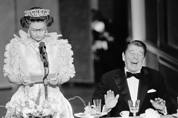 President Reagan laughs following a joke by Queen Elizabeth II, who commented on the lousy California weather she has experienced during a banquet at the De Young Museum in San Francisco in 1983. (Bettmann / Getty Images file)