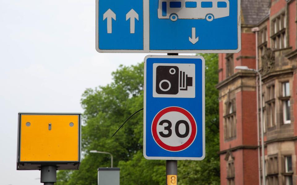 speed limit sign and camera warning - plus yellow sped camera in shot