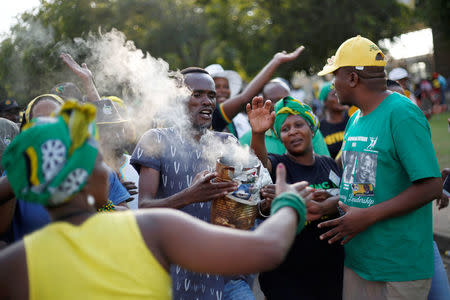 Supporters of presidential candidate Cyril Ramaphosa burn traditional herbs at the gates of the Nasrec Expo Centre, where the 54th National Conference of the ruling African National Congress (ANC) is taking place, in Johannesburg, South Africa, December 17, 2017. REUTERS/Rogan Ward