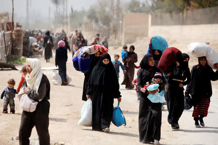 People walk with their belongings as they flee the rebel-held town of Hammouriyeh, in the village of Beit Sawa, eastern Ghouta, Syria March 15, 2018. REUTERS/Omar Sanadiki