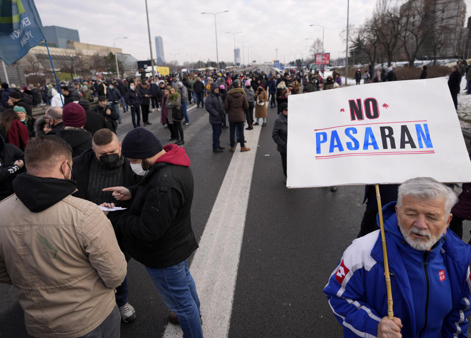 A environmental demonstrator holds a banner reading: "No Pasaran" as a highway is blocked, during a protest in Belgrade, Serbia, Saturday, Jan. 15, 2022. Hundreds of environmental protesters demanding cancelation of any plans for lithium mining in Serbia took to the streets again, blocking roads and, for the first time, a border crossing. Traffic on the main highway north-south highway was halted on Saturday for more than one hour, along with several other roads throughout the country, including one on the border with Bosnia. (AP Photo/Darko Vojinovic)