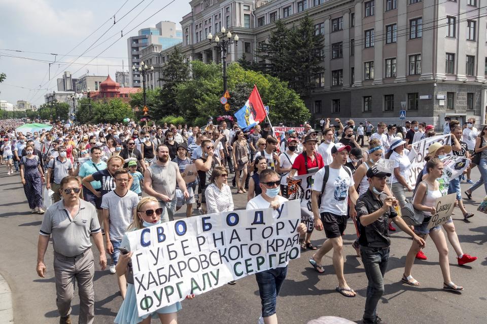 People hold posters that read: "Freedom for Khabarovsk region's governor Sergei Furgal" during an unsanctioned protest in support of Sergei Furgal, the governor of the Khabarovsk region, in Khabarovsk, 6100 kilometers (3800 miles) east of Moscow, Russia, Saturday, July 18, 2020. Tens of thousands of people in the Russian Far East city of Khabarovsk took to the streets on Saturday, protesting the arrest of the region's governor on charges of involvement in multiple murders. Local media estimated the rally in the city attracted from 15,000 to 50,000 people. (AP Photo/Igor Volkov)