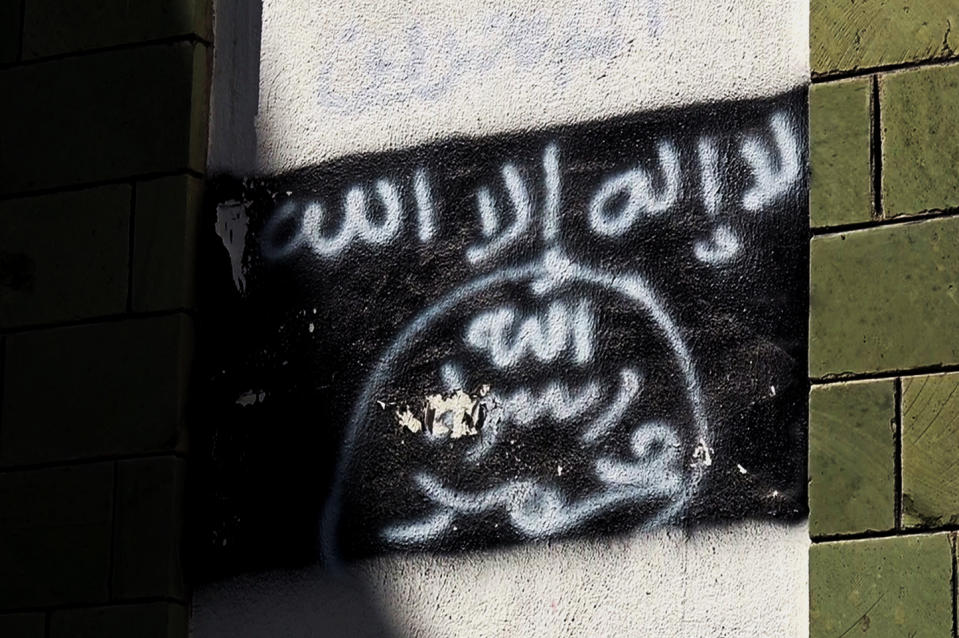 The black al-Qaida flag is sprayed on the wall of a damaged school that was turned into a religious court, in Taiz, Yemen, shown in this Oct. 16, 2017, photo. Al-Qaida fighters and other militants poured into Taiz to help defend it against Shiite rebels who have besieged it since 2015, and now the extremists are intertwined with militias financed by the U.S.-backed coalition. (AP Photo)