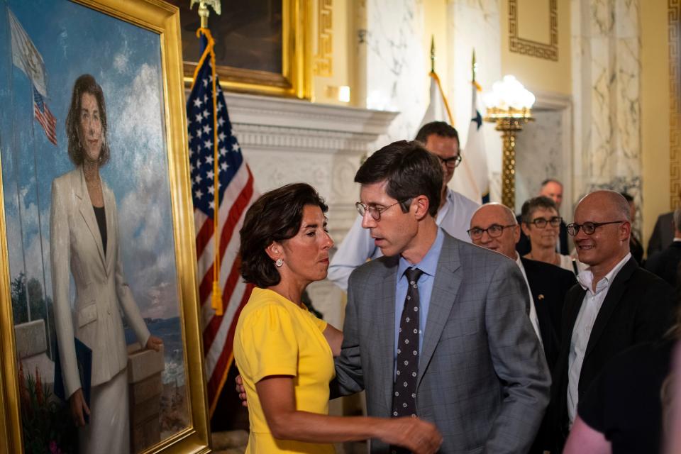 Former Gov. Gina Raimondo greets her former aide and current Providence mayor, Brett Smiley, in front of her newly unveiled portrait at the State House on Aug. 17, 2023.