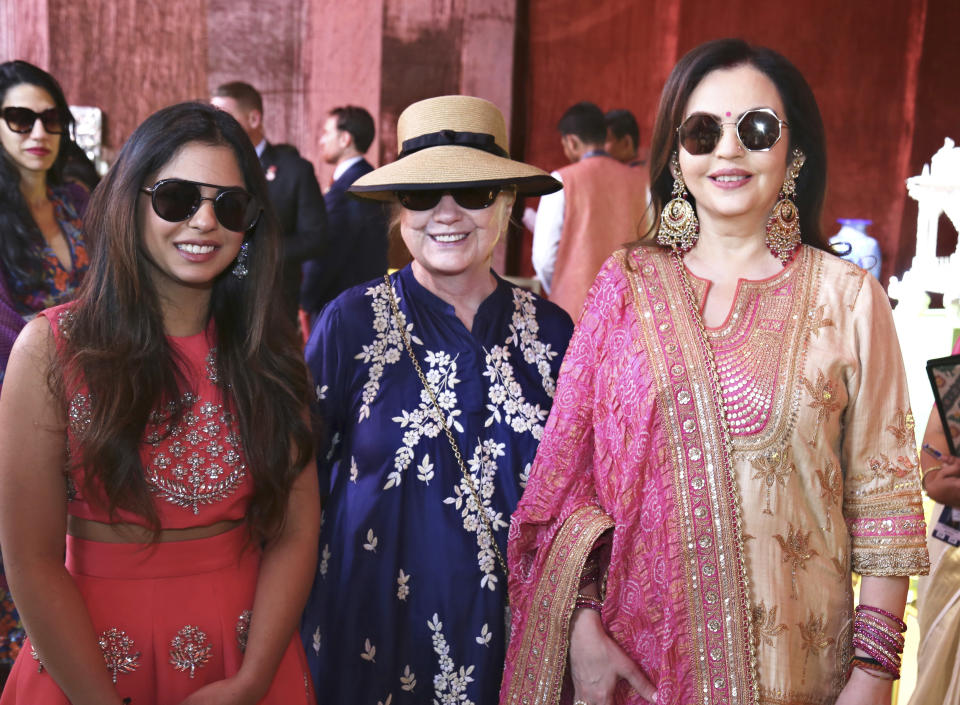 In this Sunday, Dec. 9, 2018 handout photo released by Reliance Industries Limited, former U.S. Secretary of State Hillary Clinton stands and Nita Ambani, right, visit a curated showcase of traditional Indian crafts and art forms on display ahead of the wedding of Isha Ambani, left, in Udaipur, India. Isha Ambani, the daughter of India’s richest mogul, is to wed Anand Piramal, the son of one of India’s biggest industrialists, at the Ambani estate in Mumbai on Wednesday, capping off an extravagant days-long event. (Reliance Industries Limited via AP)