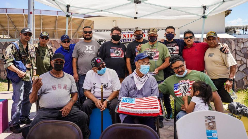 Several deported veterans gather in front of the border fence in Mexico to celebrate the Fourth of July, an event hosted in July by the Unified U.S. Deported Veterans organization based in Tijuana. (Courtesy of Robert Vivar) 
