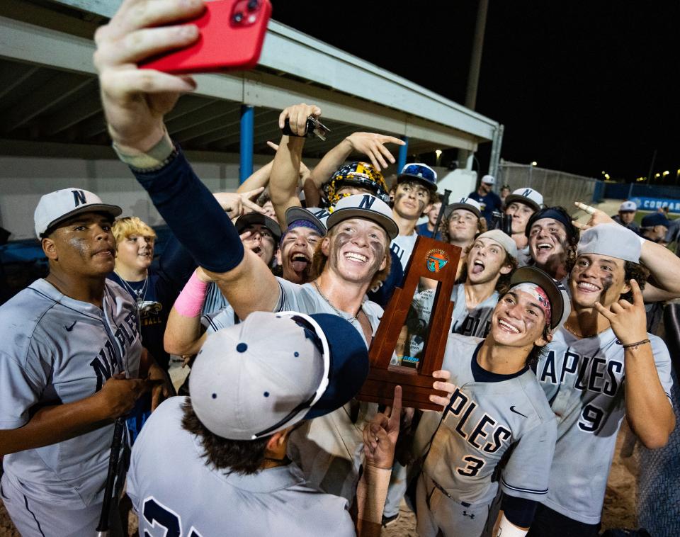 Naples Golden Eagles players take a selfie with the trophy after defeating the Barron Collier Cougars in the Class 5A District 12 championship at Barron Collier High School in Naples on Thursday, May 2, 2024.