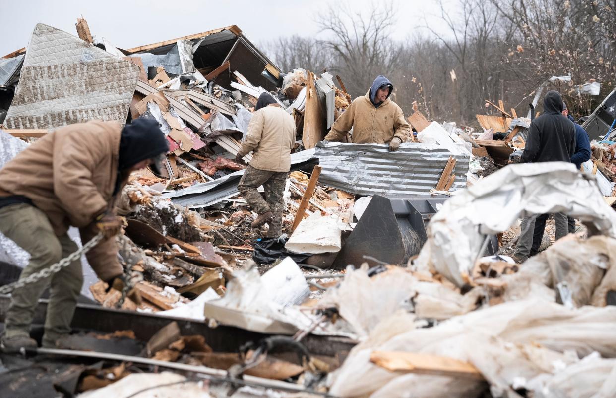 Volunteers and employees of the Foster Equipment Sales company out of Springfield, Ohio, help to clean up debris in the Geiger Mobile Home Park. Two residents of the park died when homes were destroyed during a tornado that swept through the area.