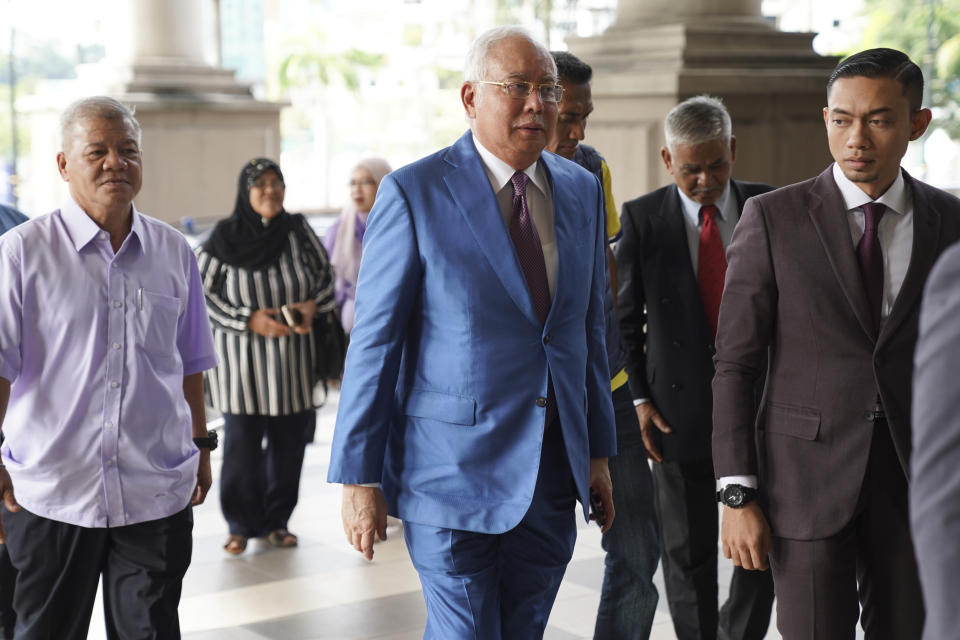 Former Malaysian Prime Minister Najib Razak, center, arrives at Kuala Lumpur High Court in Kuala Lumpur, on Tuesday, Oct. 22, 2019. Najib is facing 42 charges of corruption, abuse of power and money laundering in five separate criminal cases linked to the multibillion-dollar looting of 1MDB. (AP Photo/Vincent Thian)