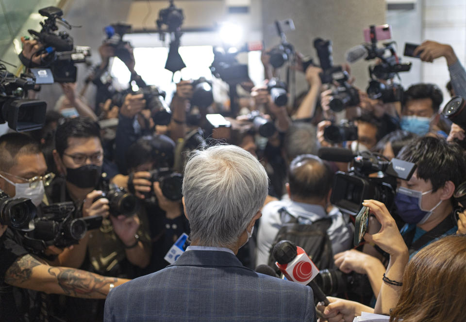 Pro-democracy activist Martin Lee, center, is surrounded by photographers outside a court after receiving a suspended sentence in Hong Kong, Friday, April 16, 2021. A Hong Kong court on Friday sentenced five leading pro-democracy advocates, including media tycoon Jimmy Lai, to up to 18 months in prison for organizing a march during the 2019 anti-government protests that triggered an overwhelming crackdown from Beijing. A total of nine advocates were given jail terms, but four of them, including 82-year-old lawyer and former lawmaker Martin Lee, had their sentences suspended after their age and accomplishments were taken into consideration. (AP Photo/Vincent Yu)