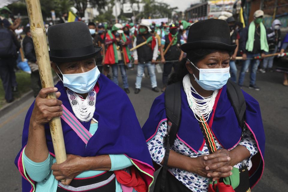 Members of the Indigenous Guard get ready to take part in an anti-government march in Bogota, where thousands traveled in a caravan from Cali, Colombia, Monday, Oct. 19, 2020. The leaders of the indigenous communities say they are mobilizing to reject massacres, assassinations of social leaders, criminalization of social protest, to defend their territory, democracy and peace, and plan to stay in the capital for a nationwide protest and strike on Oct. 21. (AP Photo/Fernando Vergara)