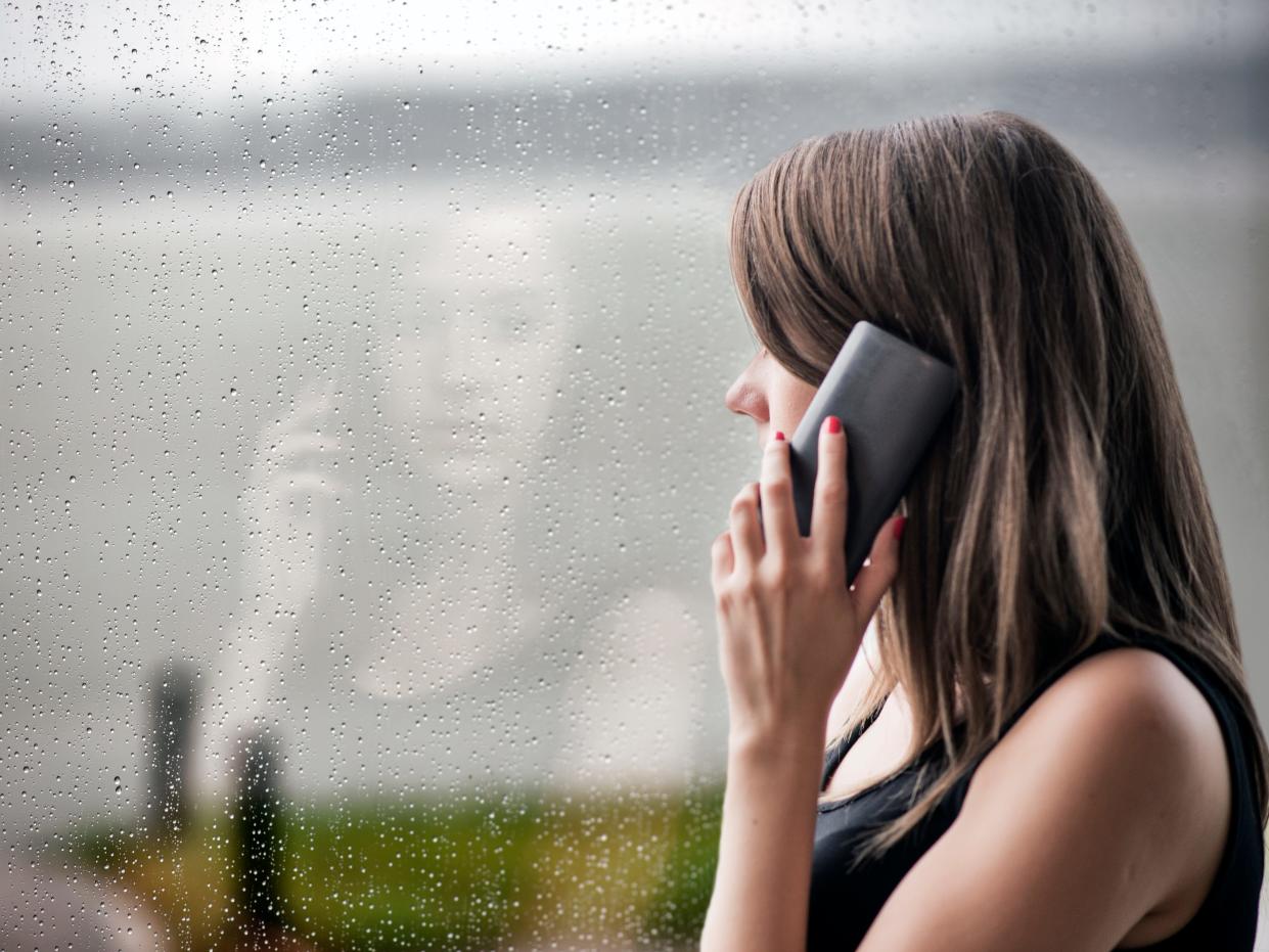 Woman looking stressed with technology , Bad news! , girl using smart phone and sitting near window, Unwanted phone call, Depression - Sadness, Sadness, Window