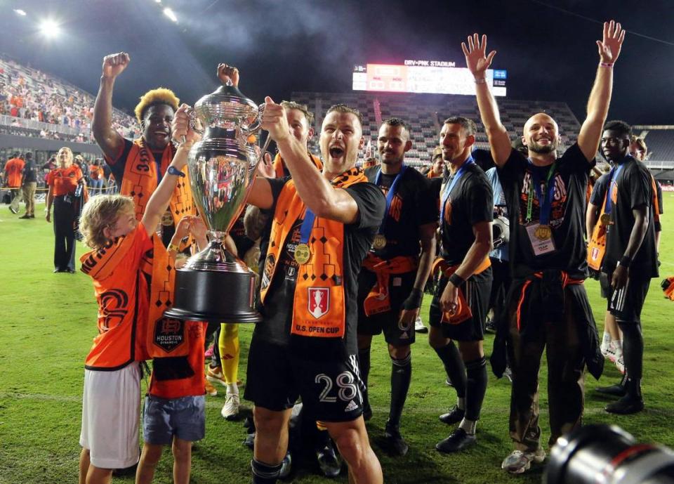 Houston Dynamo defender Erik Sviatchenko (28) raises the Lamar Hunt U.S. Open Cup in celebration with teammates and family after defeating Inter Miami at DRV PNK Stadium in Fort Lauderdale, Florida on Wednesday, September 27, 2023.