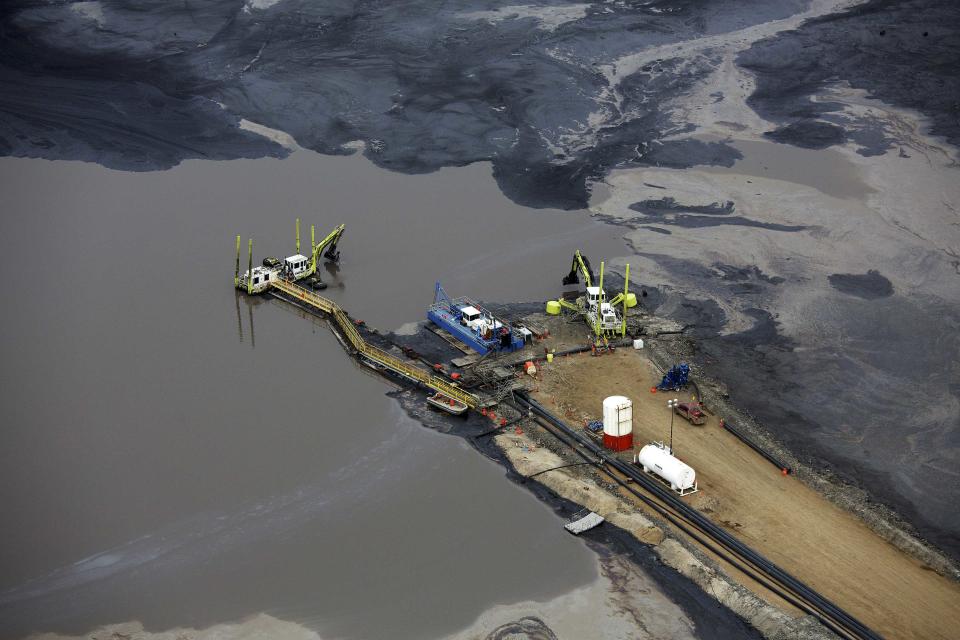 REFILE - CORRECTING DATELINE Heavy equipment works on a tailings pond at the Suncor tar sands operations near Fort McMurray, Alberta, September 17, 2014. In 1967 Suncor helped pioneer the commercial development of Canada's oil sands, one of the largest petroleum resource basins in the world. Picture taken September 17, 2014. REUTERS/Todd Korol (CANADA - Tags: ENERGY ENVIRONMENT)