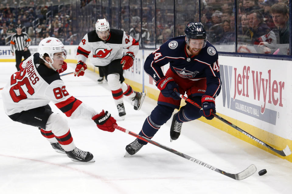 Columbus Blue Jackets defenseman Vladislav Gavrikov, right, of Russia, chases the puck in front of New Jersey forward Jack Hughes, left, and forward Miles Wood Devils during the second period an NHL hockey game in Columbus, Ohio, Saturday, Jan. 18, 2020. (AP Photo/Paul Vernon)