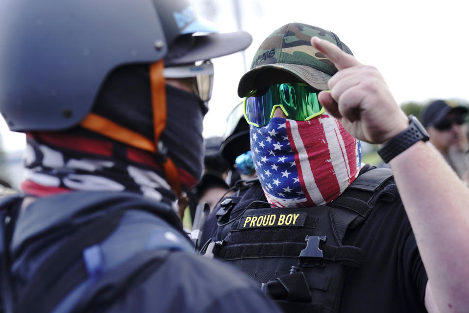 FILE - In this Sept. 26, 2020 file photo, a right-wing demonstrator gestures toward a counter protester as members of the Proud Boys and other right-wing demonstrators rally in Portland, Ore. President Donald Trump didn't condemn white supremacist groups and their role in violence in some American cities this summer. Instead, he said the violence is a “left-wing" problem and he told one far-right extremist group to “stand back and stand by.” His comments Tuesday night were in response to debate moderator Chris Wallace asking if he would condemn white supremacists and militia groups. Trump's exchange with Democrat Joe Biden left the extremist group Proud Boys celebrating what some of its members saw as tacit approval. (AP Photo/John Locher, File)