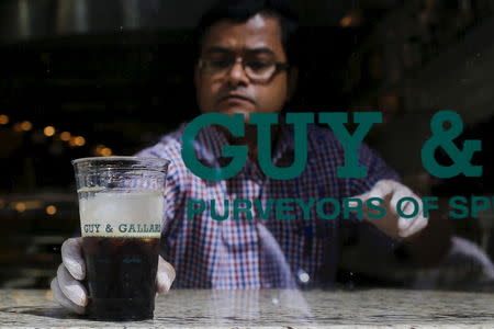 A Guy & Gallard cafeteria employee serves a nitrogen-infused cold brew coffee from Brooklyn-based roaster Gillies Coffee out of a tap at its cafeteria in New York July 31, 2015. REUTERS/Eduardo Munoz