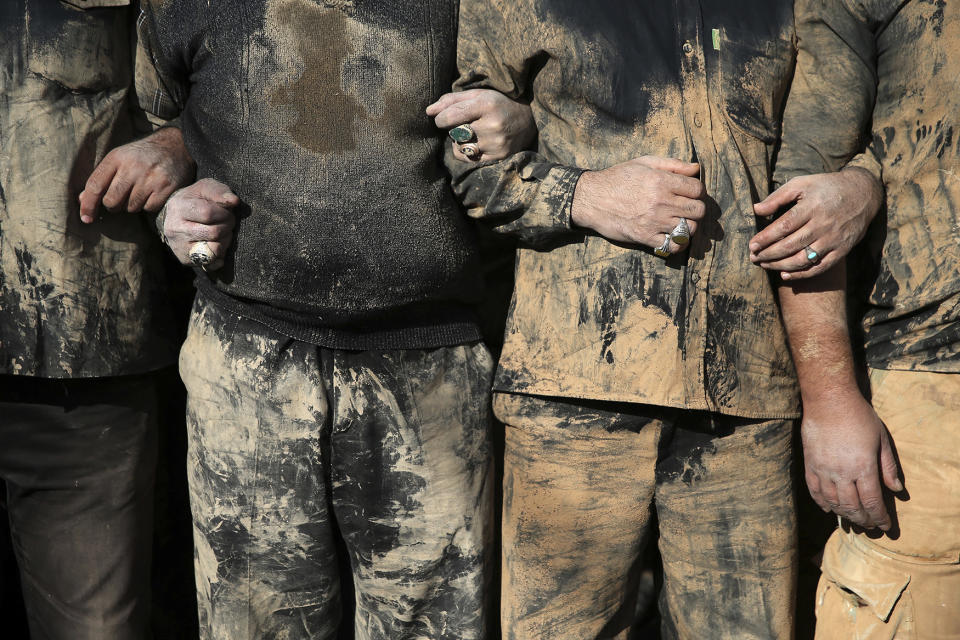 Iranian Shiite Muslims mourn after covering themselves with mud
