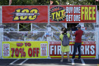 People purchase fireworks on Thursday, July 2, 2020, in Dublin, Calif. For many Americans, the Fourth of July won't be about big festivities but setting off fireworks themselves. Hundreds of cities and towns have canceled shows Saturday because of the coronavirus pandemic, and sales of consumer fireworks are booming; though officials are concerned about fires and injuries with more pyrotechnics going off in backyards and at block parties. (AP Photo/Ben Margot)