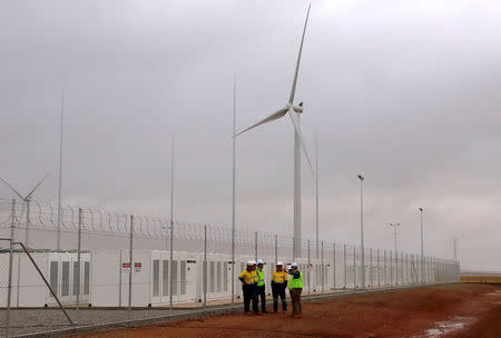 Officials and workers gather outside the compound housing the Hornsdale Power Reserve, featuring the world's largest lithium ion battery made by Tesla, during the official launch near the South Australian town of Jamestown, in Australia, December 1, 2017. REUTERS/David Gray