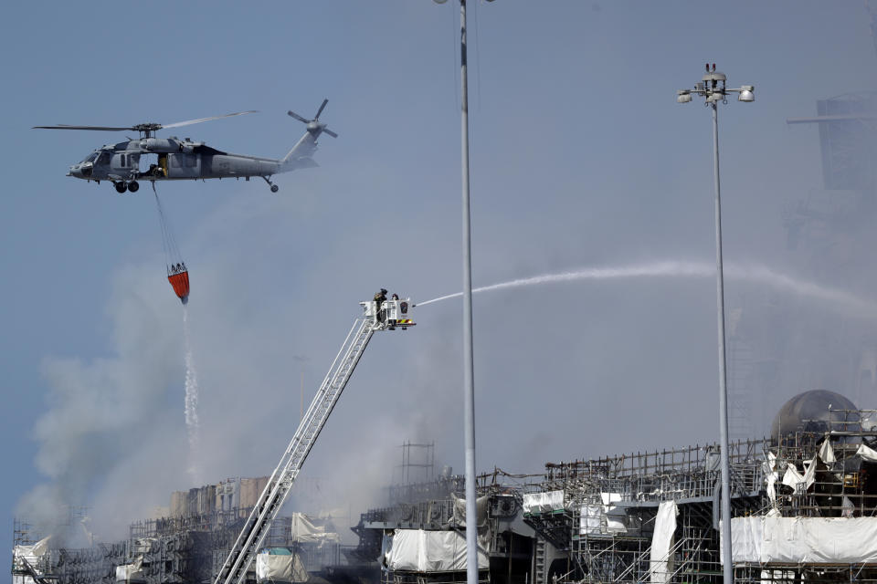 Fire crews battle the fire on the USS Bonhomme Richard, Monday, July 13, 2020, in San Diego. Fire crews continue to battle the blaze Monday after 21 people suffered minor injuries in an explosion and fire Sunday on board the USS Bonhomme Richard at Naval Base San Diego. (AP Photo/Gregory Bull)