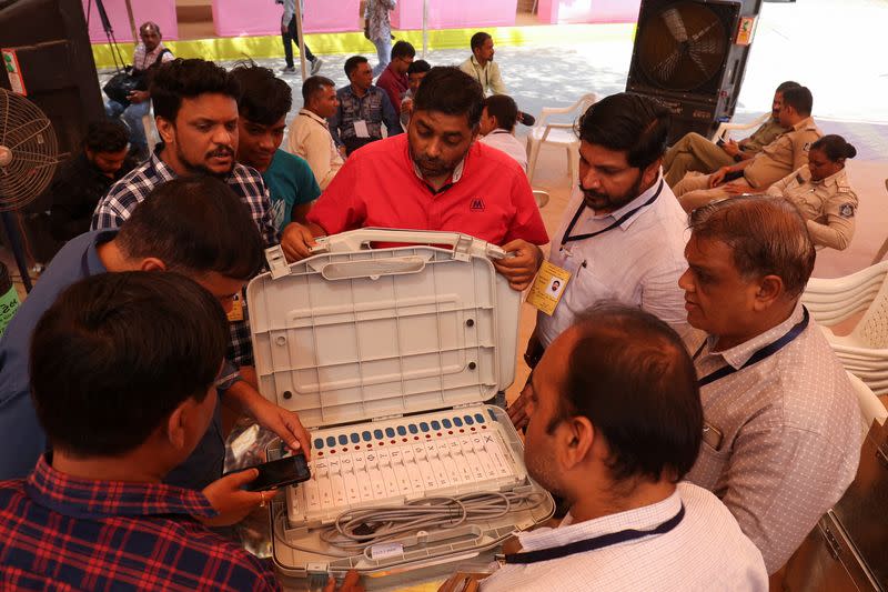 Election staff scan serial numbers of Electronic Voting Machines (EVM) before dispatching them from a warehouse ahead of India's general election in Ahmedabad