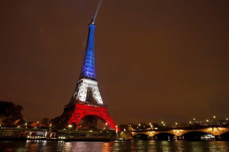 The Eiffel Tower is lit with the blue, white and red colours of the French flag in Paris, France, November 16, 2015, to pay tribute to the victims of a series of deadly attacks on Friday in the French capital. REUTERS/Benoit Tessier