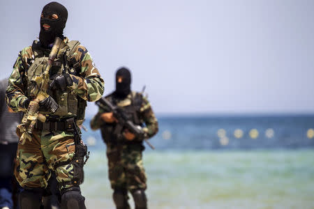 FILE PHOTO: Tunisia's special forces secure the beachside of the Imperial Marhaba resort, while British, French, German and Tunisia's interior minister arrive to pay their tribute in front of a makeshift memorial in Sousse, Tunisia, June 29, 2015. REUTERS/Zohra Bensemra/File Photo