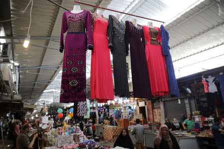 Dresses are offered for a sale inside a market in eastern Mosul, Iraq, April 19, 2017. REUTERS/Marko Djurica