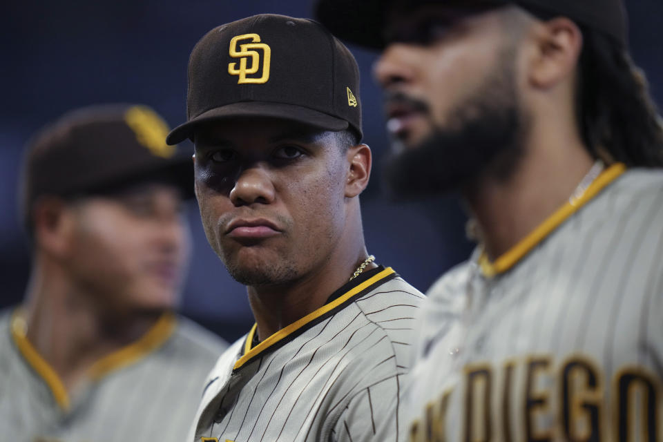 San Diego Padres left fielder Juan Soto, center, looks over at Fernando Tatis Jr. as they come off the field after the eighth inning of a baseball game against the Toronto Blue Jays on Tuesday, July 18, 2023, in Toronto. (Chris Young/The Canadian Press via AP)