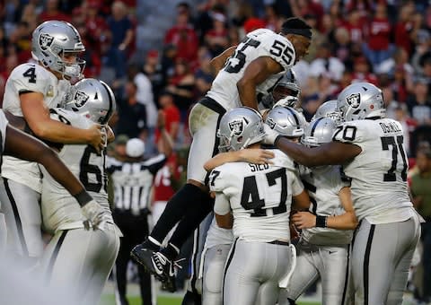 The Oakland Raiders celebrate as time expires during the second half of an NFL football game against the Arizona Cardinals - Credit: AP Photo/Rick Scuteri