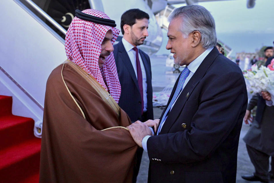 In this photo released by Ministry of Foreign Affairs, Pakistani's Foreign Minister Ishaq Dar, right, greets his Saudi counterpart Prince Faisal bin Farhan upon his arrival at a military airbase in Rawalpindi, Pakistan, Monday, April 15, 2024. Saudi Arabia's foreign minister led a high-level delegation on a two-day visit to Pakistan, which is seeking help in overcoming one of its worst economic crises. (Ministry of Foreign Affairs via AP)