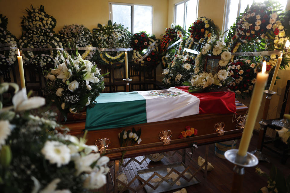 Flowers surround the flag-draped coffin of environmental activist Homero Gomez Gonzalez at his wake in Ocampo, Michoacan state, Mexico, Thursday, Jan. 30, 2020. Relatives of the anti-logging activist who fought to protect the winter habitat of monarch butterflies don't know whether he was murdered or died accidentally, but they say they do know one thing for sure: something bad is happening to rights and environmental activists in Mexico, and people are afraid. (AP Photo/Rebecca Blackwell)