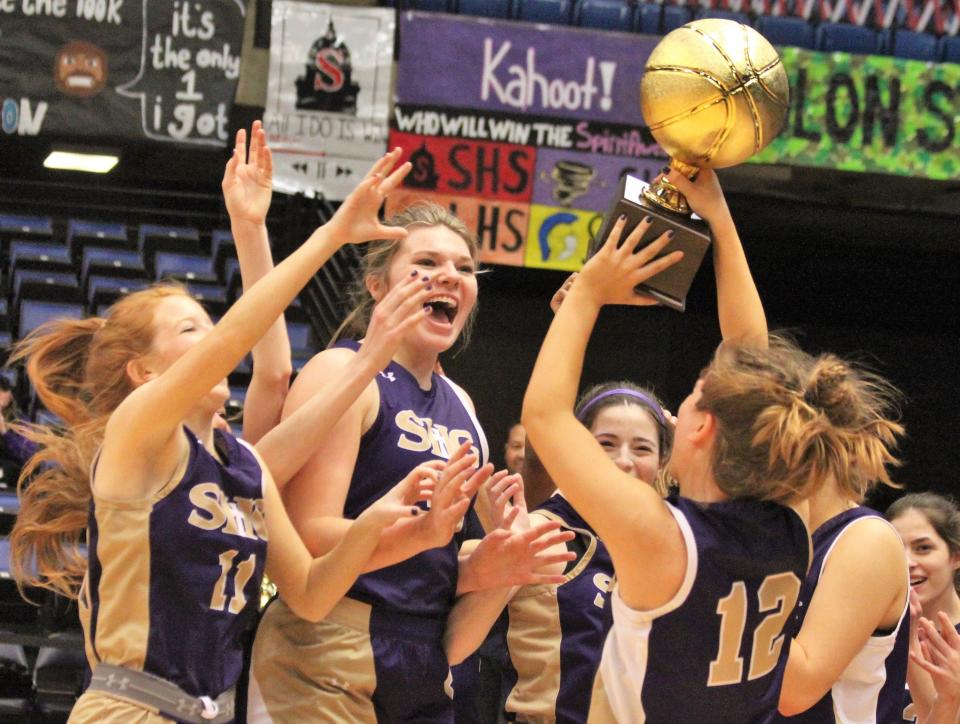 Sacred Heart-Griffin's Hannah Lambert (12) hoists the City tournament trophy following a 52-20 girls basketball victory over Lanphier at the Bank of Springfield Center on Saturday, Jan. 28, 2023.