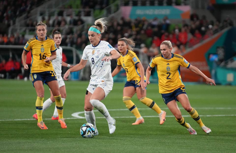 Julie Ertz dribbles through three defenders during the USA's Round of 16 game against Sweden at the 2023 Women's World Cup.