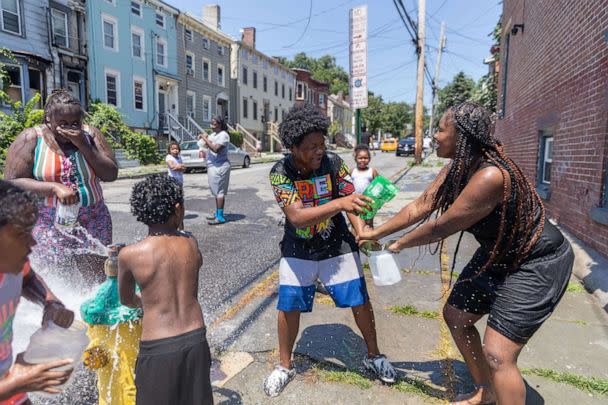 PHOTO: People play in front of an open fire hydrant during hot weather in Newburgh, N.Y., July 19, 2022. (Times Herald Record via USA Today)